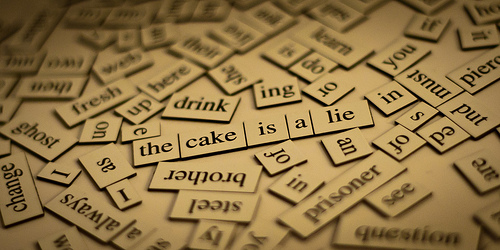 A picture of many pieces of a puzzle of words showing the composition of the sentence the cake is a lie.