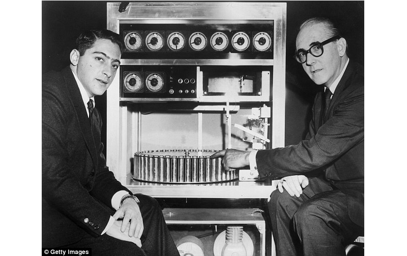 US film producer Mike Todd Jr sits with Swiss inventor Hans Laube, who points to his Smell-O-Vision machine